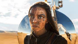 Anya Taylor-Joy as the titular Furiosa, stood with a scowl on her face, covered in dirt.